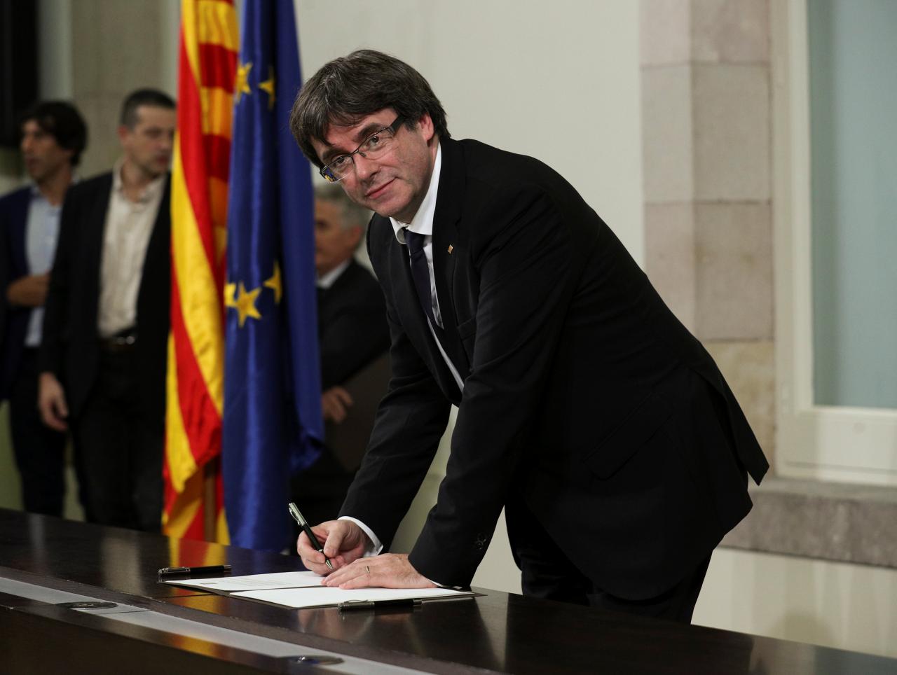 Catalan President Carles Puigdemont signs a declaration of independence at the Catalan regional parliament in Barcelona, Spain, October 10, 2017. REUTERS/Albert Gea