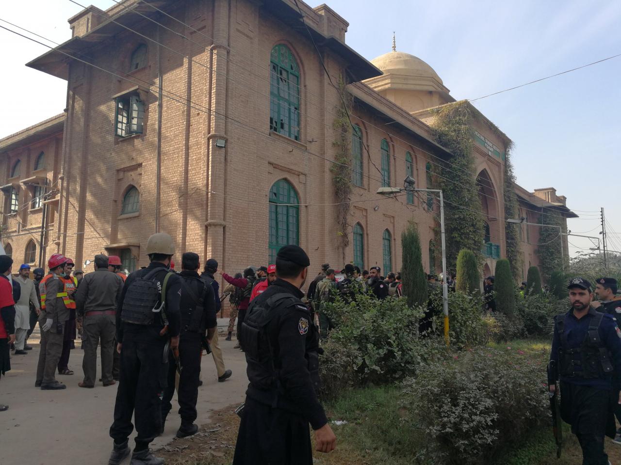 Police and rescue workers stand outside the Directorate of Agriculture Institute in Peshawar