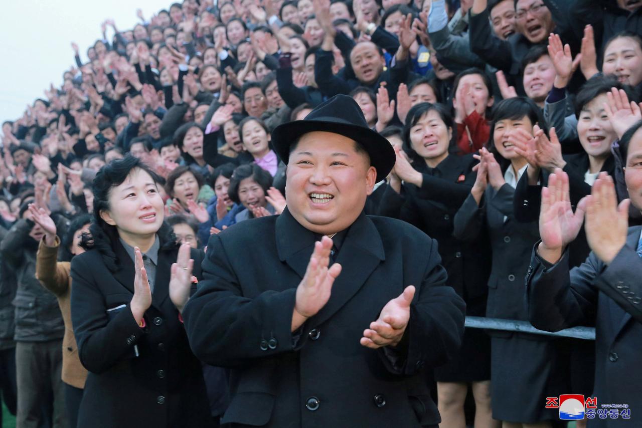 North Korean leader Kim Jong Un reacts as people applaud during his visit to the newly-remodeled Pyongyang Teacher Training College