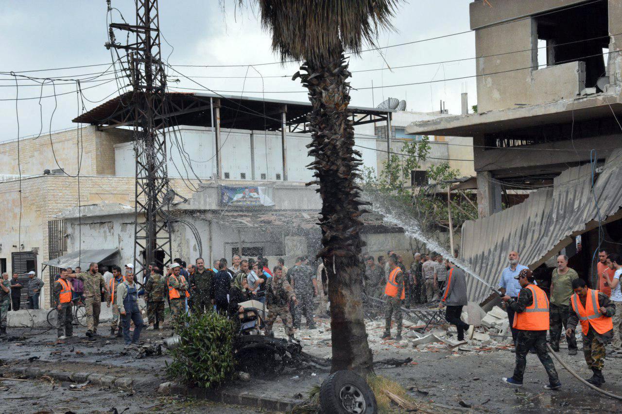 Men put off a fire after an explosion in the al-Zahraa neighbourhood of Homs city