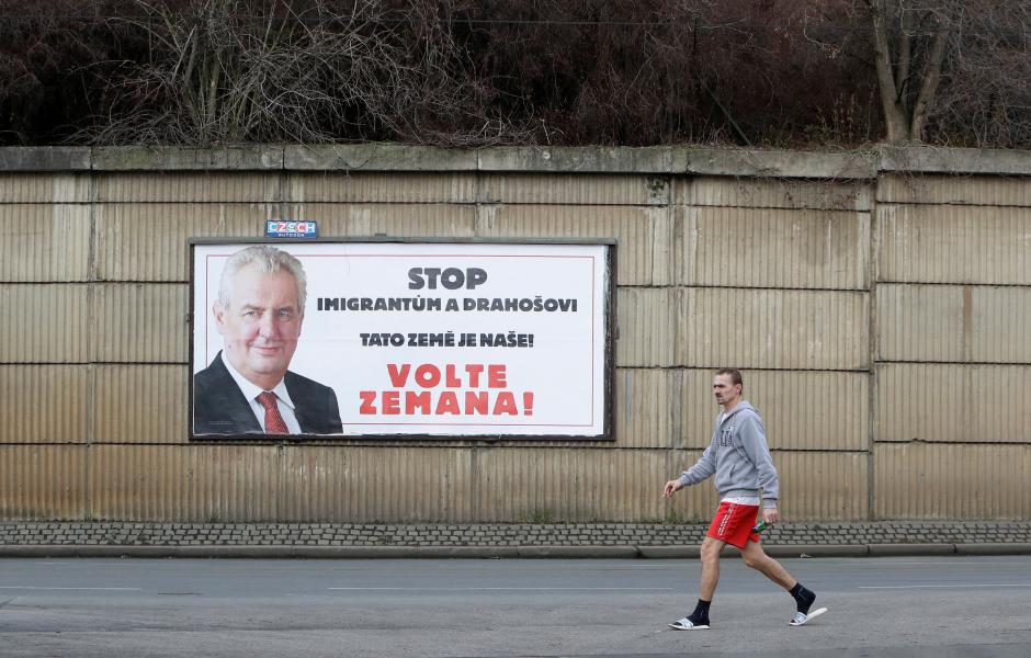 A man walks past a poster promoting the incumbent president Milos Zeman in Prague